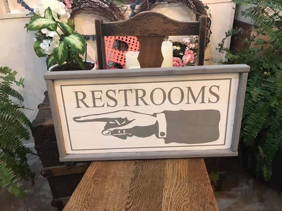 Restroom with hand pointing